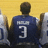Pixelated image of a person in a dark blue jersey with number 3 on the back, standing against a yellow background.