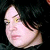 Pixelated close-up of a person's face with light skin, dark hair, and closed eyes against a black background.
