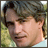 nine showing a person with light brown hair in a light blue shirt against a blurred green background, with text elements appearing in the bottom-right