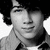 Black-and-white portrait of a person with voluminous curly hair wearing a collared shirt, displayed in a