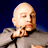 Static pixelated image of a bald character with closed eyes wearing a gray suit against a dark blue background.