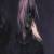 Pixelated static image of a figure with long hair and dark clothing against a dark background, showing partial light-colored footwear.