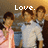 Three pixelated figures stand side-by-side under a warm-toned background with the word 'Love.' in white text above them.