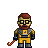 Pixel art character with brown hair, black glasses, and a red beard wearing yellow armor over dark sleeves holding an orange curved object against gray background.