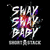 A split-screen image with a colorful 'Shay Baby' text graphic on the left and a grayscale group photo of three people on the right.