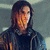 A person with long dark hair and a dark jacket appears in a of six , with text overlays changing
