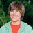 A person with brown hair appears in three distinct poses: standing, sitting with arms crossed, and close-up smiling.