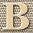 A static pixelated image of a large stylized letter B with rounded edges on a checkered background.