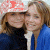 Two people in close proximity, one wearing a red and white patterned cap and dark clothing, the other in blue jacket with light hair.