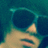 A person wearing dark sunglasses with a teal frame, visible in three of a