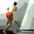 A shirtless man in red shorts performs a running motion with arms swinging, viewed from behind against a light gray background.