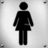Black pixelated silhouette of a standing figure with rounded head, straight arms, and long dress or coat against light gray background.