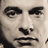 Pixelated grayscale close-up of a human face with dark eyebrows, nose, and mouth against light skin tones.