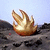 Pixelated icon of a golden, flame-like shape with multiple upward-pointing tips against a light blue sky and dark rocky terrain.