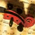A pixelated red and black insect-like creature with large eyes and segmented body on a beige background.