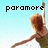 A pixelated image of a woman with red hair in a green dress, arms outstretched against a light blue background, with text reading "paramore rocks my socks!".