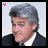 A pixelated image of a person with gray hair wearing a dark suit and white shirt, shown in two side-by-side frames where the head turns slightly right.