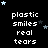 Black background with white pixelated text reading "plastic smiles real tears" repeated in a , surrounded by small light blue and dark gray stars