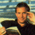 A pixelated image of a person in dark clothing holding an object near their face against a blurred background, with green text reading "Original Icons .com" on the right.