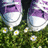 A static pixelated image shows a pair of white boots with purple accents standing on green grass dotted with small yellow-centered flowers.