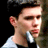 Pixelated static image of a person's face and upper torso in profile view with dark hair, light skin tone, wearing white shirt over black garment against dark background.