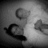 Grayscale pixelated image with three distinct curved shapes against a gradient background, one dark and two lighter tones.