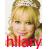 Pixelated static image of a person with blonde hair in an updo, wearing red clothing and visible text at the bottom.