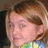 Pixelated image of a person with light brown hair and a colorful patterned shirt, next to red text on a black background.