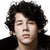 A pixelated image of a person with curly dark hair wearing a dark jacket, with blue text and symbols overlaid on the right side.