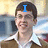 A person in a brown jacket and white collared shirt appears across three with changing blue text overlays