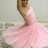 A pixelated image shows a figure in a flowing pink dress with a brown upper body against a muted background.