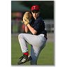 Static image of a baseball player in mid-pitching motion wearing dark jersey, white pants, red socks, and red cap with visible 'T' logo, holding brown leather glove on grass field background.