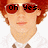 Pixelated image of a person with red hair and sunglasses, wearing a white shirt and brown bow tie, with text overlays across the face.