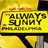 Yellow rectangular sign with black border displays 'ALWAYS SUNNY' in large blocky letters, 'IN PHILADELPHIA' below, and orange flame-like shapes at top.