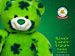 Static green teddy bear icon with dark blue clover patterns, white nose and mouth area, black eyes, and a small circular emblem on the right side against a solid green background.