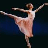 A pixelated ballet dancer in a pink tutu performing an arabesque pose on one leg with arms extended, next to white text reading "grace glides on blistered feet" on a black background.