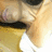 Pixelated close-up of a figure with light skin tone, dark hair, and yellow clothing against a beige background.