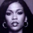 Pixelated static image of a person's face with dark hair, hoop earrings, and neutral expression on gray background.