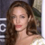 A pixelated close-up of a person with long brown hair, wearing a light-colored strapless top, against a dark background with partial white text.
