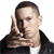 Pixelated image of a person with short dark hair wearing a dark jacket over a white shirt, making a hand gesture near their face.