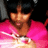 Pixelated image of a person with dark hair wearing a bright pink top against a dark background.