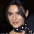 Pixelated close-up of a person with dark hair, light skin, and a black choker with white dots against a dark background.