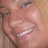 A pixelated close-up of a person's face showing eyes, nose, and mouth with visible teeth in a smiling expression.