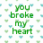 Green pixelated text on a white background with repeating small blue and green heart shapes, partially obscured by a gray rectangle.