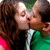 Two figures in close embrace, one with long dark hair and green clothing, the other with light hair and a white-and-green outfit, sharing a kiss.