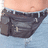 A pixelated image shows a person's lower torso in light blue jeans with dark gray pants partially pulled down, revealing the waistband and belt. Purple text on black background reads "i wear my fanny pack to the side cause it's cool".
