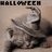 A pixelated static image shows a figure with light skin and dark hair holding a white object against a beige background, with 'HALLOWEEN' text at the top.