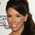 A static pixelated image shows a person with dark hair tied back, light skin, and a smiling expression against a light background with faint gray patterns.
