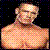 Pixelated static image of a shirtless male figure with light skin tone, bald head, and neutral expression against dark background.