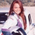A pixelated image of a person with long brown hair wearing a white top and dark pants, standing against a light background.